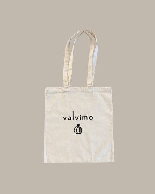 Luonnonvalkoinen kangaskassi pitkillä kantohihnoilla ja Valvimo-logolla.