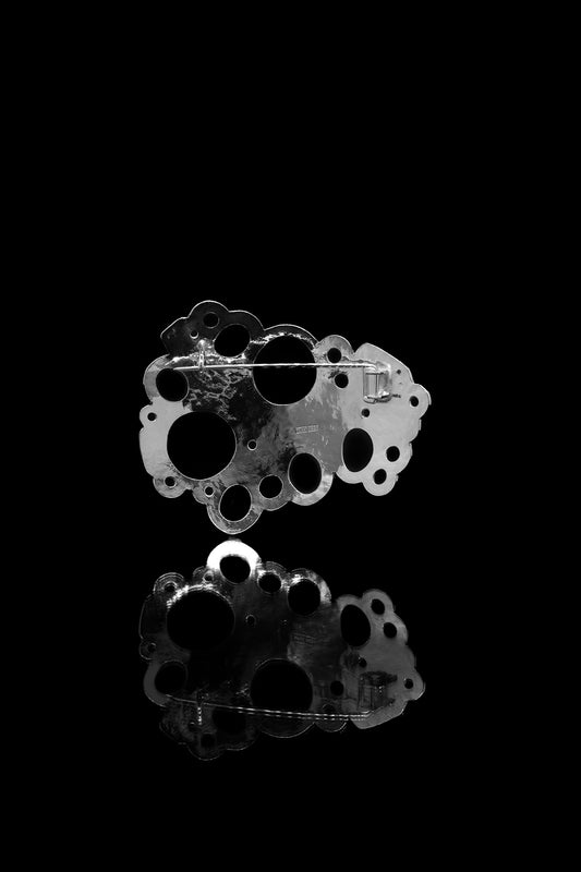 Hopeinen Rannalla-rintaneula takaapäin kuvattuna.