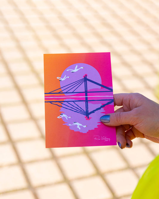 Puna-oranssi Rovaniemi-aiheinen postikortti, josta voi tunnistaa Jätkänkynttilä sillan.