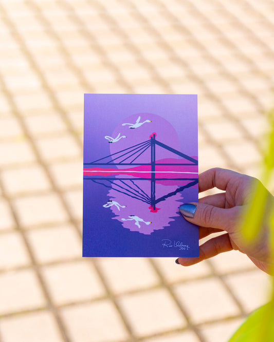 Rovaniemi-aiheinen postikortti, josta voi tunnistaa Jätkänkynttilä-sillan ja kaksi lentävää joutsenta, jotka heijastuvat peilikiiltävästä joesta.