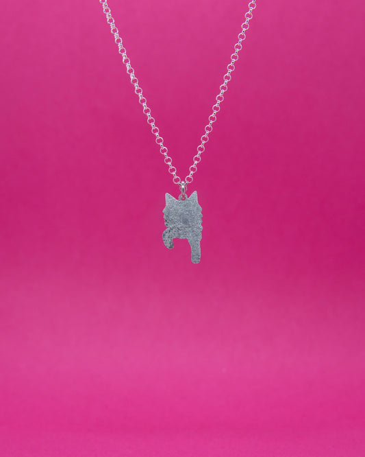 Mattapintainen pienikokoinen hopeariipus jossa pitkäkarvaisen kissan siluetti edestä kuvattuna. Riipus roikkuu sirossa hopeisessa papuketjussa.