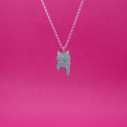 Mattapintainen pienikokoinen hopeariipus jossa pitkäkarvaisen kissan siluetti edestä kuvattuna. Riipus roikkuu sirossa hopeisessa papuketjussa.