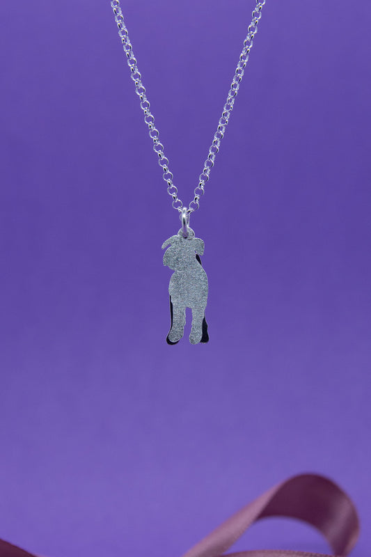 Hopeakaulakoru kaksiosaisella riipuksella, joka esittää suursnautseria. Riipus on edestä mattapintainen. Kaulakorussa on siro papuketju.