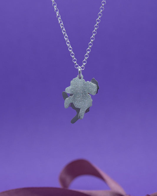 Hopeinen kaulakoru, jossa on Villakoiraa esittävä kaksiosainen riipus. Riipuksessa on osien toiset puolet matattu ja toiset kiiltäviä.