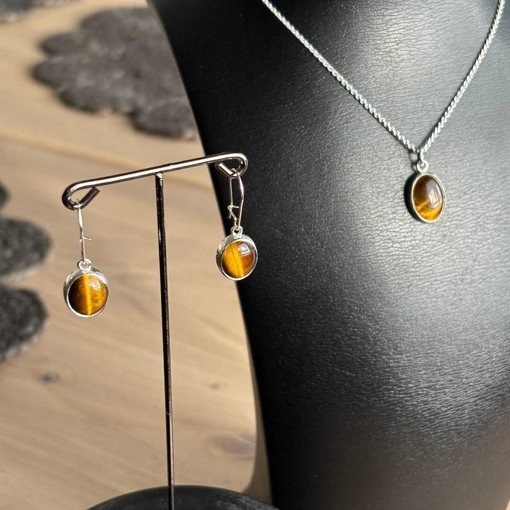 Hopeiset korvakorut lukittavalla koukkumekanismilla. Koruihin on istutettu käsin ovaalit tiikerinsilmät.