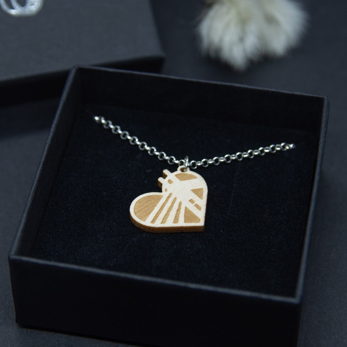 Rovaniemi-aiheinen pieni vanerikaulakoru. Korussa on hopeaketju ja riipuksesta voi tunnistaa Jätkänkynttilä-sillan siluetin.