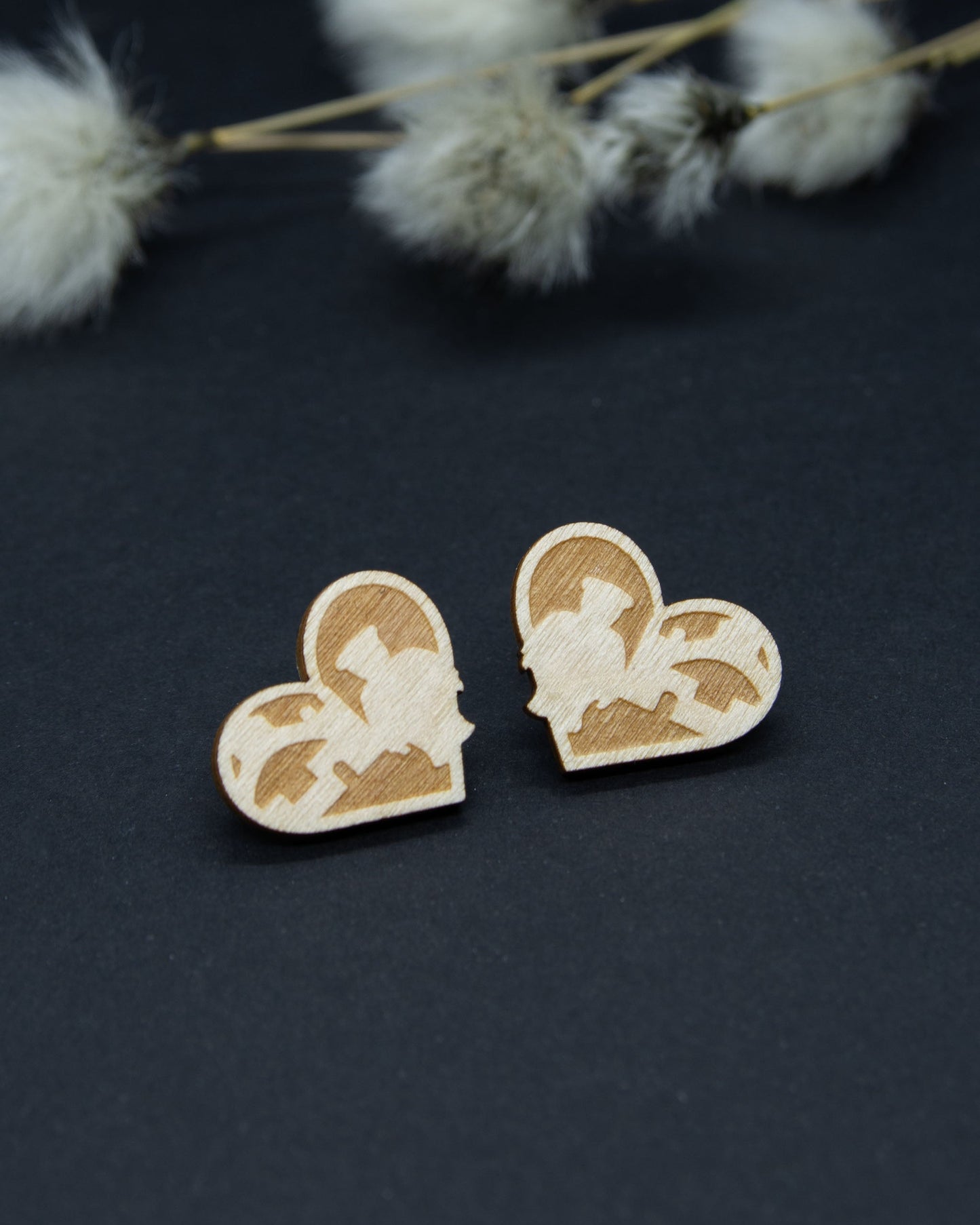 Oulu-aiheiset nappikorvakorut. Puunväristä koivuvaneria. Korujen kehämuoto on sydämen mallinen.