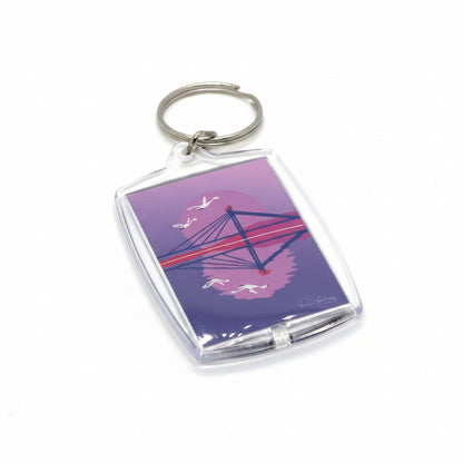 Violetin sävyinen avaimenprä Rovaniemi-aiheella. Avaimenperässä Riia Valvimon teos "Kesä saapuu Rovaniemelle II".