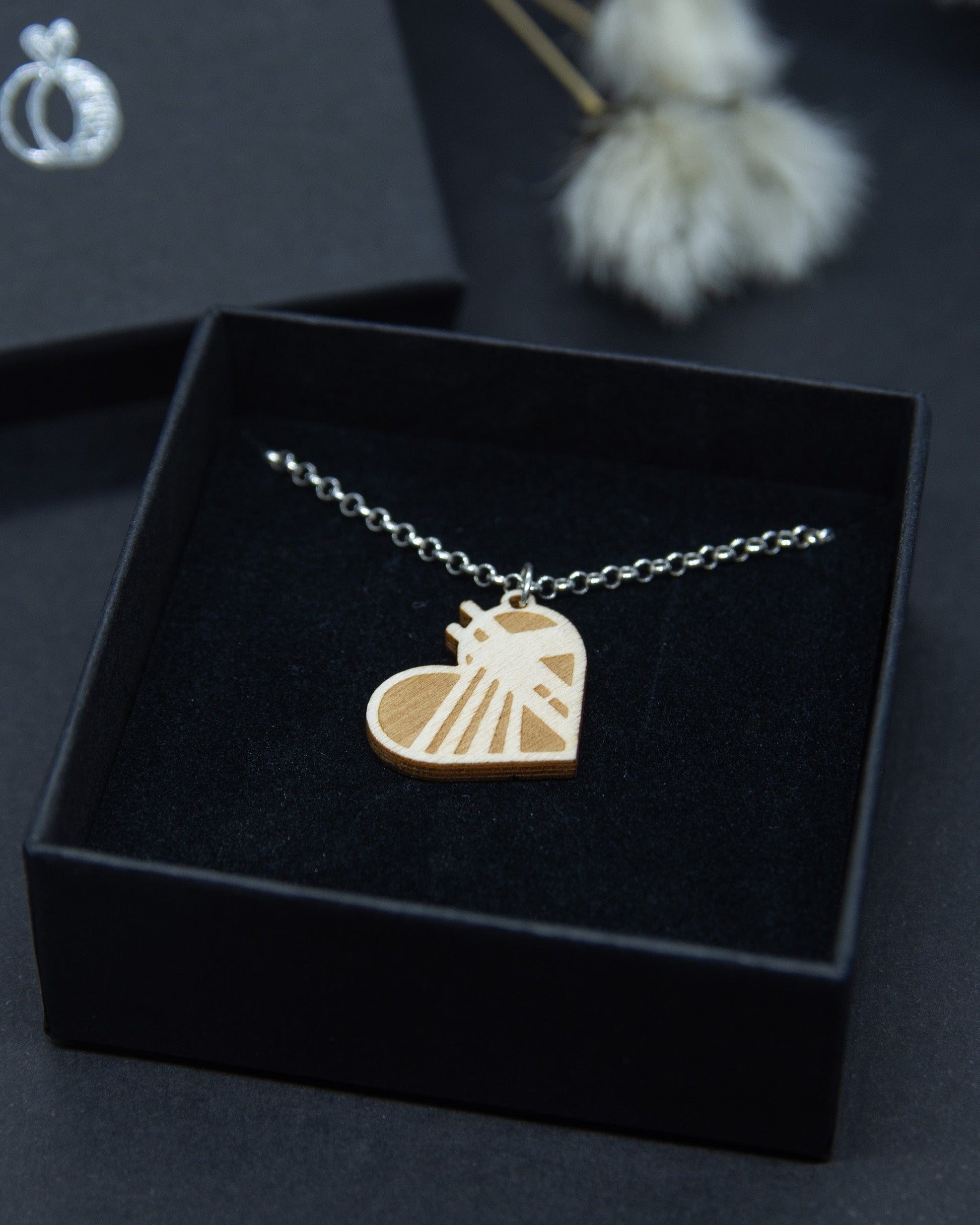 Rovaniemi-aiheinen pieni vanerikaulakoru. Korussa on hopeaketju ja riipuksesta voi tunnistaa Jätkänkynttilä-sillan siluetin.